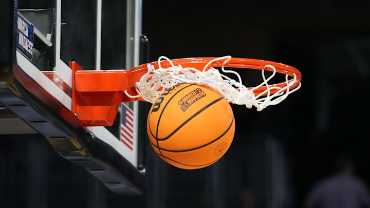 Mar 19, 2025; Wichita, KS, USA; A Wilson official NCAA Evo NXT basketball with the March Madness logo approaches the rim and the net at Intrust Bank Arena.
