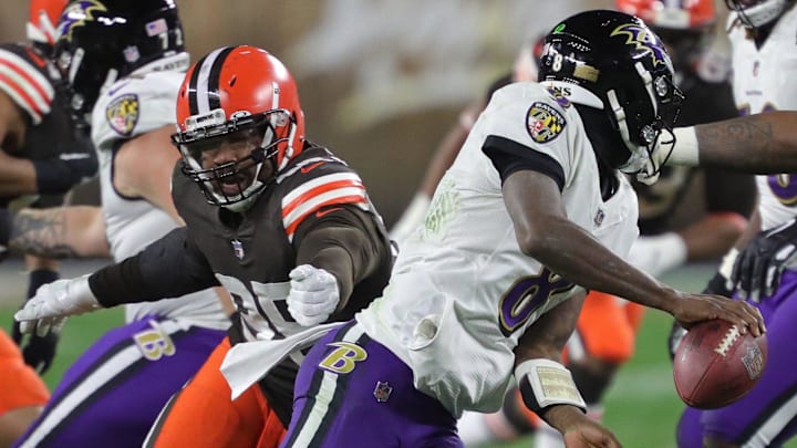 Baltimore Ravens quarterback Lamar Jackson (8) narrowly escapes Cleveland Browns defensive end Myles Garrett (95) as he scrambles for yards during the first half of an NFL football game, Monday, Dec. 14, 2020, in Cleveland, Ohio.