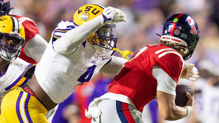 Oct 12, 2024; Baton Rouge, Louisiana, USA;  LSU Tigers defensive end Bradyn Swinson (4) sacks Mississippi Rebels quarterback Jaxson Dart (2) during the second half at Tiger Stadium. Mandatory Credit: Stephen Lew-Imagn Images