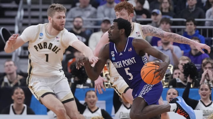 High Point Panthers forward Kimani Hamilton (5) dribbles the ball against Purdue Boilermakers forward Caleb Furst (1) and center Will Berg (44) during the first half at Amica Mutual Pavilion. 