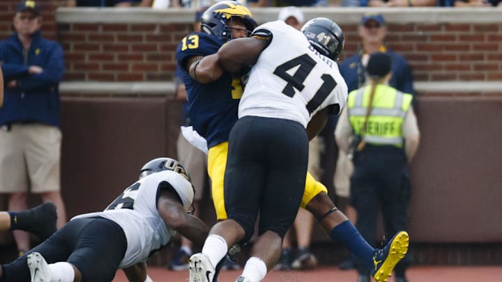 Michigan Wolverines wide receiver Eddie McDoom is hit by UCF Knights linebacker Demeitre Brim. Michigan Wolverines wide receiver Eddie McDoom is hit by UCF Knights linebacker Demeitre Brim.