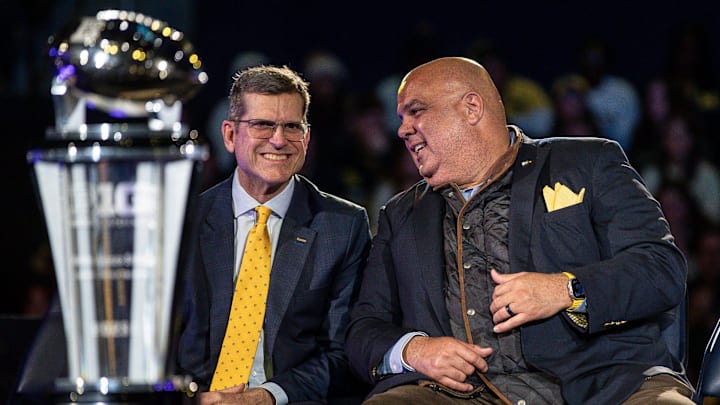 Michigan head football coach Jim Harbaugh talks to athletic director Warde Manuel during the national championship celebration in Ann Arbor on Saturday, Jan. 13, 2024.