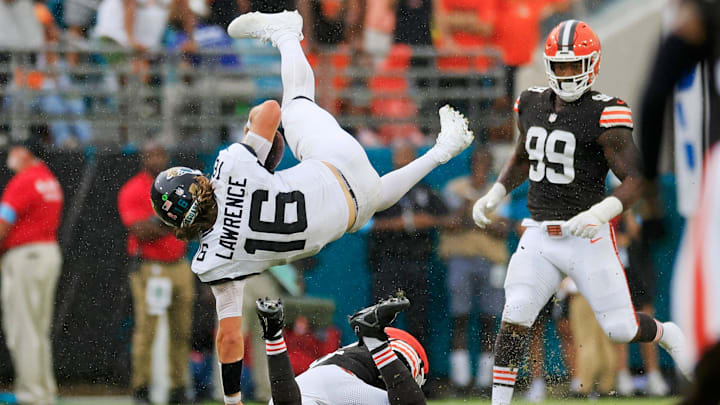 Jacksonville Jaguars quarterback Trevor Lawrence (16) is upended by Cleveland Browns linebacker Jeremiah Owusu-Koramoah (6) as defensive end Za'Darius Smith (99) looks on during the fourth quarter of an NFL football matchup Sunday, Sept. 15, 2024 at EverBank Stadium in Jacksonville, Fla. The Browns defeated the Jaguars 18-13.