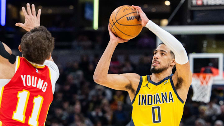 Jan 5, 2024; Indianapolis, Indiana, USA; Indiana Pacers guard Tyrese Haliburton (0) shoots the ball while Atlanta Hawks guard Trae Young (11) defends in the first half at Gainbridge Fieldhouse. Mandatory Credit: Trevor Ruszkowski-Imagn Images