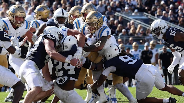 Oct 5, 2024; University Park, Pennsylvania, USA; UCLA Bruins running back Jalen Berger (0) attempts to push forward with the ball against the Penn State Nittany Lions defense during the fourth quarter at Beaver Stadium. Mandatory Credit: Matthew O'Haren-Imagn Images
