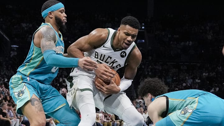 Nov 17, 2023; Charlotte, North Carolina, USA; Milwaukee Bucks forward Giannis Antetokounmpo (34) tries to elude Charlotte Hornets forward Miles Bridges (0) and guard LaMelo Ball (1) during the second half at the Spectrum Center. Mandatory Credit: Jim Dedmon-Imagn Images
