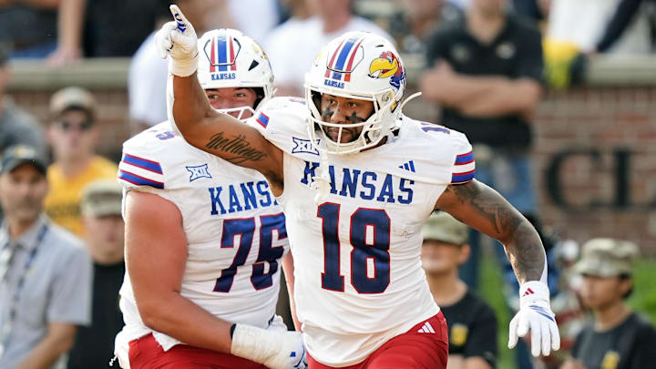 Sep 6, 2025; Columbia, Missouri, USA; Kansas Jayhawks tight end DeShawn Hanika (18) celebrates with offensive lineman Antonio Wilson (76) after scoring a touchdown during the second half against the Missouri Tigers at Faurot Field at Memorial Stadium. Mandatory Credit: Jay Biggerstaff-Imagn Images Sep 6, 2025; Columbia, Missouri, USA; Kansas Jayhawks tight end DeShawn Hanika (18) celebrates with offensive lineman Antonio Wilson (76) after scoring a touchdown during the second half against the Missouri Tigers at Faurot Field at Memorial Stadium. Mandatory Credit: Jay Biggerstaff-Imagn Images