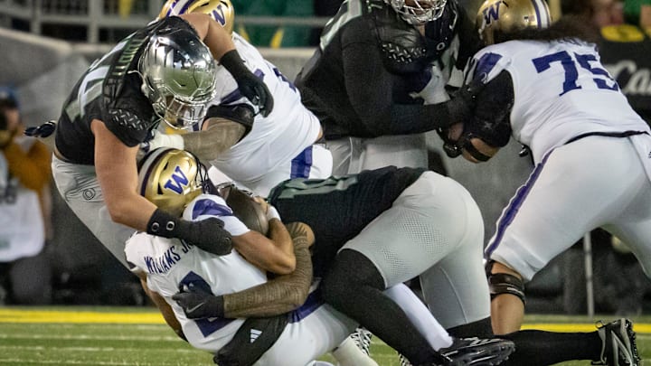 Oregon outside linebackers Matayo Uiagalelei, right, and Teitum Tuioti, left, sack Washington quarterback Demond Williams Jr.  The Ducks had 40 sacks last season, good for 14th in the country: Good, not great.