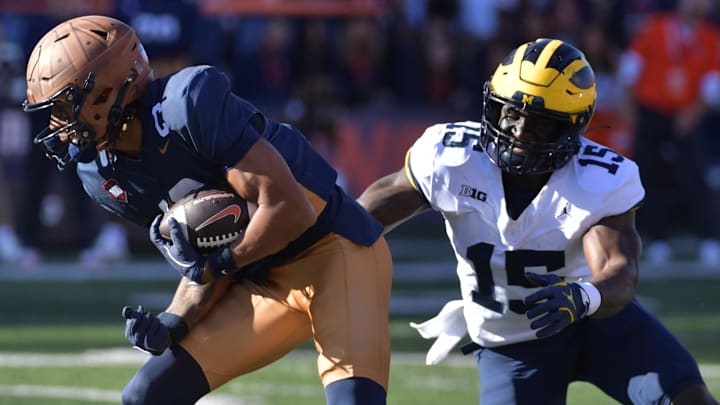 Oct 19, 2024; Champaign, Illinois, USA;  Illinois Fighting Illini wide receiver Pat Bryant (13) makes a short catch and run against Michigan Wolverines linebacker Ernest Hausmann (15) during the first half at Memorial Stadium.
