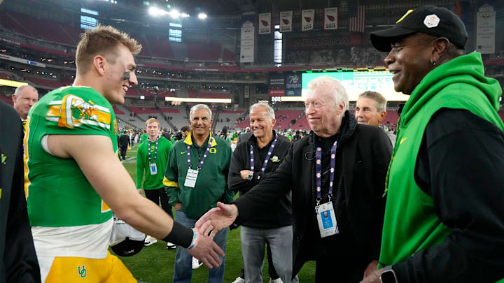 Oregon Ducks quarterback Bo Nix greets Phil Knight after defeating the Liberty Flames to win the Fiesta Bowl