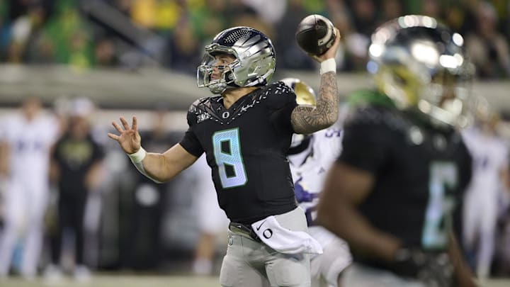 Nov 30, 2024; Eugene, Oregon, USA; Oregon Ducks quarterback Dillon Gabriel (8) fakes a pass as he runs into the end zone for a touchdown during the first half against the Washington Huskies at Autzen Stadium. Mandatory Credit: Troy Wayrynen-Imagn Images