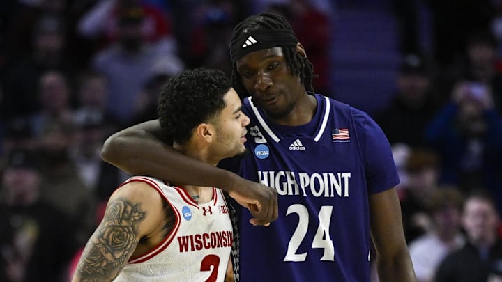 Mar 19, 2026; Portland, OR, USA; High Point Panthers center Youssouf Singare (24) embraces Wisconsin Badgers guard Nick Boyd (2) during the second half of a first round game of the men's 2026 NCAA Tournament at Moda Center. Mandatory Credit: Troy Wayrynen-Imagn Images
