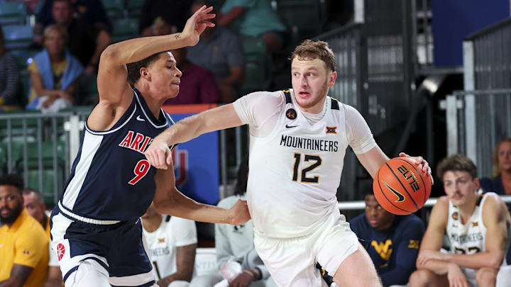 Nov 29, 2024; Paradise Island, Bahamas, BHS;  West Virginia Mountaineers guard Tucker DeVries (12) drives to the basket as Arizona Wildcats forward Carter Bryant (9) defends during the second half at Imperial Arena at the Atlantis resort.  Mandatory Credit: Kevin Jairaj-Imagn Images