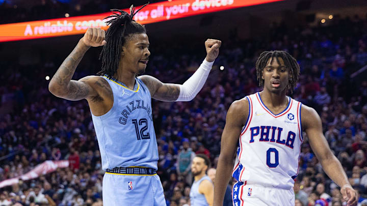 Jan 31, 2022; Philadelphia, Pennsylvania, USA; Memphis Grizzlies guard Ja Morant (12) reacts in front of Philadelphia 76ers guard Tyrese Maxey (0) after dunking the ball during the third quarter at Wells Fargo Center. Mandatory Credit: Bill Streicher-Imagn Images