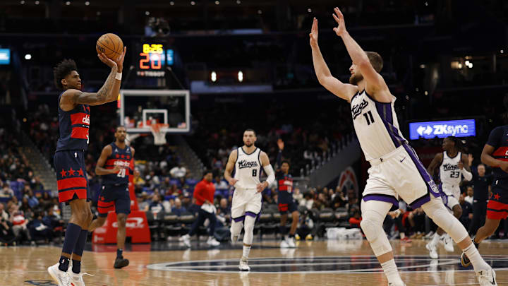 Apr 2, 2025; Washington, District of Columbia, USA; Washington Wizards guard AJ Johnson (5) shoots the ball as Sacramento Kings forward Domantas Sabonis (11) defends in the second half at Capital One Arena. Mandatory Credit: Geoff Burke-Imagn Images
