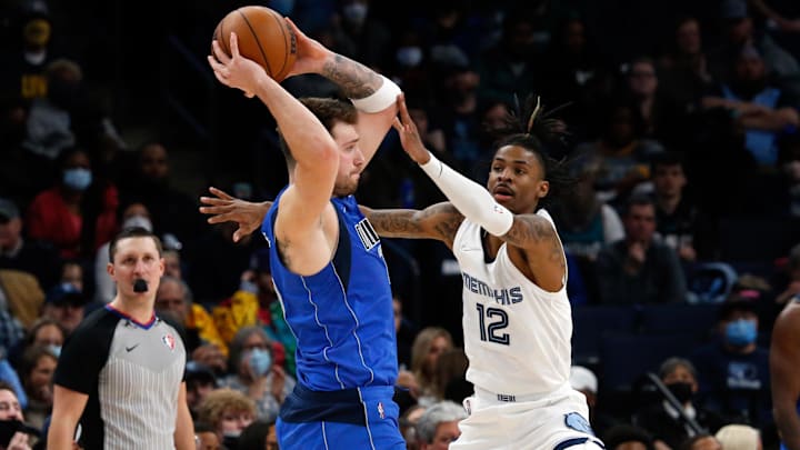  Dallas Mavericks guard Luka Doncic (77) passes the ball as Memphis Grizzles guard Ja Morant (12) defends during the first half at FedExForum. Mandatory Credit: Petre Thomas-Imagn Images