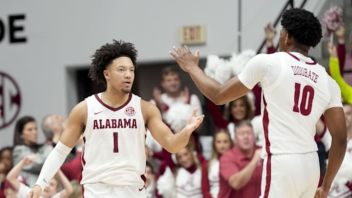 Feb 1, 2025; Tuscaloosa, AL, USA;  Alabama Crimson Tide guard Mark Sears (1) celebrates with forward Mouhamed Dioubate (10) during a timeout against the Georgia Bulldogs at Coleman Coliseum. Alabama won 90-69. Mandatory Credit: Gary Cosby Jr/USA TODAY Network via Imagn Images