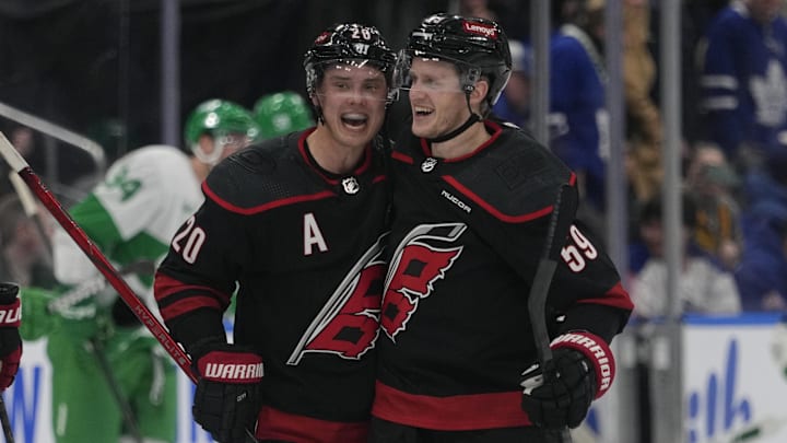 Mar 16, 2024; Toronto, Ontario, CAN; Carolina Hurricanes forward Sebastian Aho (20) congratulates forward Jake Guentzel (59) for scoring the winning goal against the Toronto Maple Leafs during the overtime shoot out at Scotiabank Arena. Mandatory Credit: John E. Sokolowski-Imagn Images