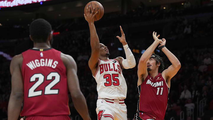 Jan 31, 2026; Miami, Florida, USA;  Chicago Bulls forward Isaac Okoro (35) takes a shot over Miami Heat forward Jaime Jaquez Jr. as forward Andrew Wiggins (22) looks on during the first half at Kaseya Center. Mandatory Credit: Jim Rassol-Imagn Images