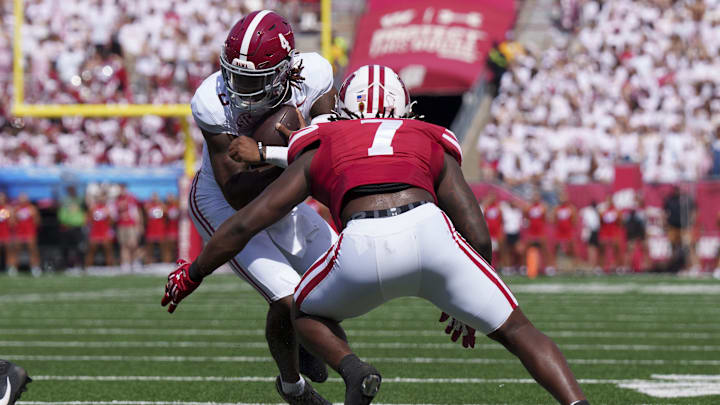 Sep 14, 2024; Madison, Wisconsin, USA; Alabama Crimson Tide quarterback Jalen Milroe (4) is tackled by Wisconsin Badgers linebacker Jaheim Thomas (7) during the second quarter at Camp Randall Stadium. Mandatory Credit: Jeff Hanisch-Imagn Images Sep 14, 2024; Madison, Wisconsin, USA; Alabama Crimson Tide quarterback Jalen Milroe (4) is tackled by Wisconsin Badgers linebacker Jaheim Thomas (7) during the second quarter at Camp Randall Stadium. Mandatory Credit: Jeff Hanisch-Imagn Images