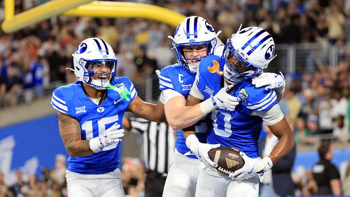 Dec 27, 2025; Orlando, FL, USA; BYU Cougars cornerback Evan Johnson (0) is congratulated after intercepting the ball during the second half at Camping World Stadium. Mandatory Credit: Kim Klement Neitzel-Imagn Images
