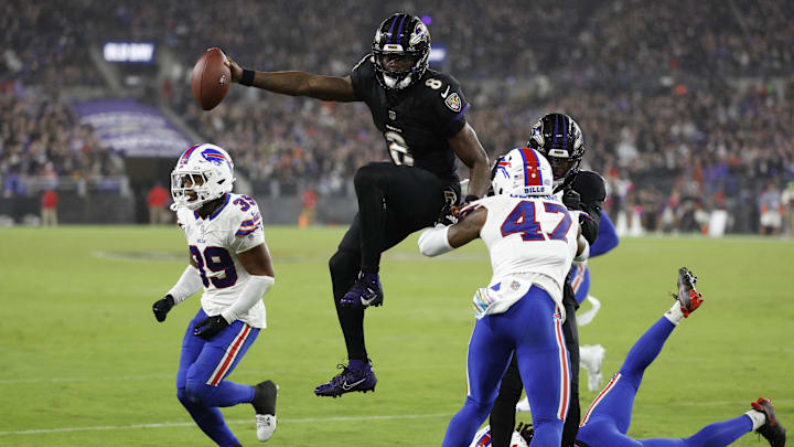 Baltimore Ravens quarterback Lamar Jackson (8) scores a touchdown as Buffalo Bills safety Damar Hamlin (3) and cornerback Christian Benford (47) defend during the third quarter at M&T Bank Stadium. 