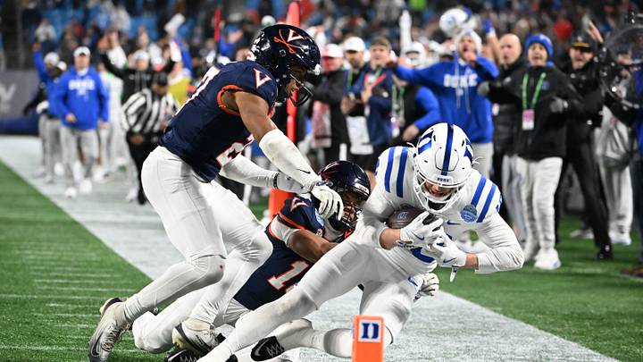 Dec 6, 2025; Charlotte, NC, USA; Duke Blue Devils wide receiver Cooper Barkate (18) catches a pass near the goal line as Virginia Cavaliers safety Devin Neal (27) and safety Corey Costner (18) defend in the fourth quarter during the ACC Championship game at Bank of America Stadium. Mandatory Credit: Bob Donnan-Imagn Images Dec 6, 2025; Charlotte, NC, USA; Duke Blue Devils wide receiver Cooper Barkate (18) catches a pass near the goal line as Virginia Cavaliers safety Devin Neal (27) and safety Corey Costner (18) defend in the fourth quarter during the ACC Championship game at Bank of America Stadium. Mandatory Credit: Bob Donnan-Imagn Images