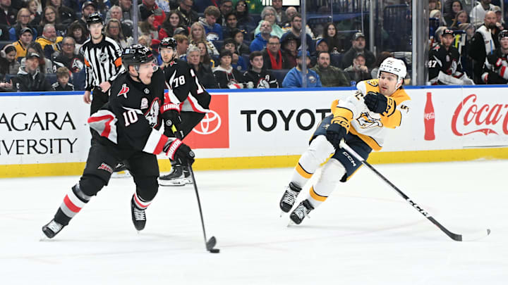 Jan 31, 2025; Buffalo, New York, USA; Buffalo Sabres defenseman Henri Jokiharju (10) keeps the puck away from Nashville Predators center Tommy Novak (82) in the first period at the KeyBank Center. Mandatory Credit: Mark Konezny-Imagn Images