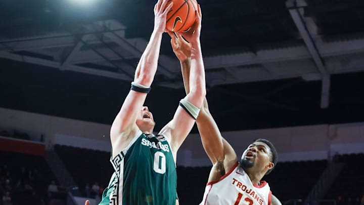 Feb 1, 2025; Los Angeles, California, USA;  Michigan State Spartans forward Jaxon Kohler (0) grabs a layup against USC Trojans forward Rashaun Agee (12) during the first half at Galen Center. Mandatory Credit: William Navarro-Imagn Images