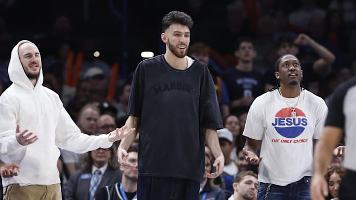 Oklahoma City Thunder guard Alex Caruso (9), forward Chet Holmgren (7), and forward Jalen Williams (8) watch their team play against the Milwaukee Bucks.