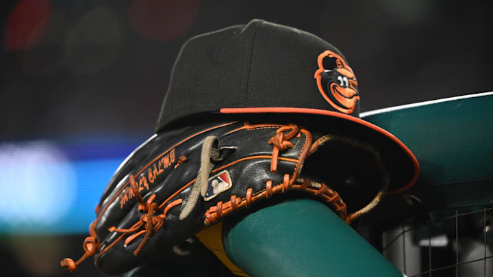 May 8, 2024; Washington, District of Columbia, USA; A Baltimore Orioles hat and glove rest on the dugout rail during a game against the Washington Nationals at Nationals Park. Mandatory Credit: Rafael Suanes-Imagn Images