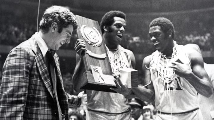 Indiana head coach Bobby Knight celebrates with forward Scott May (center) and guard Quinn Buckner (21) after winning the 1976 NCAA basketball championship. 