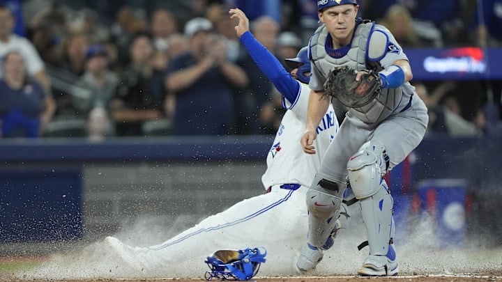 Nov 1, 2025; Toronto, Ontario, CAN; Toronto Blue Jays second baseman Isiah Kiner-Falefa (7) is out against Los Angeles Dodgers catcher Will Smith (16) in the ninth inning during game seven of the 2025 MLB World Series at Rogers Centre. Mandatory Credit: John E. Sokolowski-Imagn Images