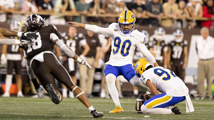 Sep 17, 2022; Kalamazoo, Michigan, USA; Pittsburgh Panthers holder Cam Guess (92) holds the ball for kicker Ben Sauls (90) as Western Michigan Bronco Keni-H Lovely (18) attempts to block the ball in the first quarter at Waldo Stadium. Mandatory Credit: Kimberly Moss-Imagn Images