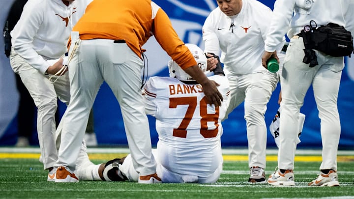 Trainers help Texas Longhorns offensive lineman Kelvin Banks Jr. (78) off the field after an injury in the third quarter as the Texas Longhorns play the Arizona State Sun Devils in the Peach Bowl College Football Playoff quarterfinal at Mercedes-Benz Stadium in Atlanta, Georgia, Jan. 1, 2025.