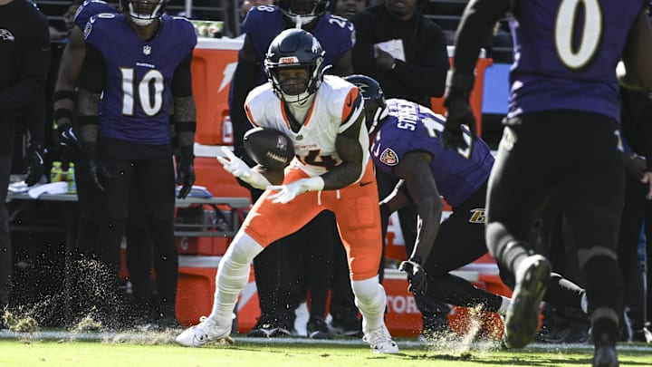 Nov 3, 2024; Baltimore, Maryland, USA; Denver Broncos wide receiver Courtland Sutton (14) secures a catch in front of Baltimore Ravens cornerback Brandon Stephens (21)  during the first quarter at M&T Bank Stadium. 
