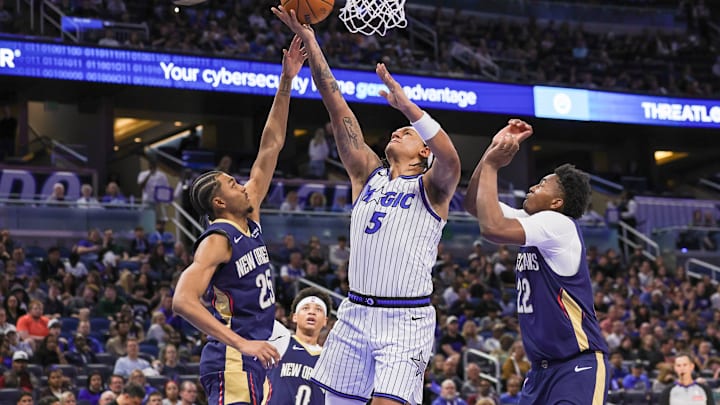 Jan 11, 2026; Orlando, Florida, USA; Orlando Magic forward Paolo Banchero (5) goes to the basket against New Orleans Pelicans center Derik Queen (22) and forward Trey Murphy III (25) during the second half at Kia Center. Mandatory Credit: Mike Watters-Imagn Images Jan 11, 2026; Orlando, Florida, USA; Orlando Magic forward Paolo Banchero (5) goes to the basket against New Orleans Pelicans center Derik Queen (22) and forward Trey Murphy III (25) during the second half at Kia Center. Mandatory Credit: Mike Watters-Imagn Images