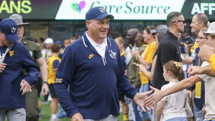 Sep 27, 2025; Morgantown, West Virginia, USA; West Virginia Mountaineers head coach Rich Rodriguez walks on the field and greets fans before their game against the Utah Utes at Milan Puskar Stadium. Mandatory Credit: Ben Queen-Imagn Images