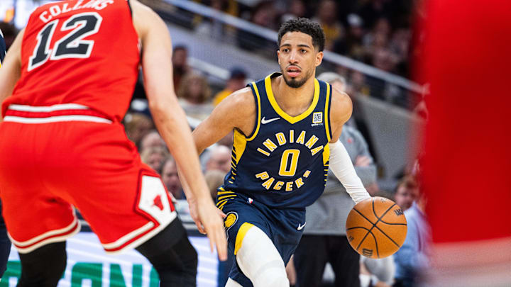 Mar 2, 2025; Indianapolis, Indiana, USA; Indiana Pacers guard Tyrese Haliburton (0) dribbles the ball while Chicago Bulls forward Zach Collins (12) defends in the second half  at Gainbridge Fieldhouse. Mandatory Credit: Trevor Ruszkowski-Imagn Images