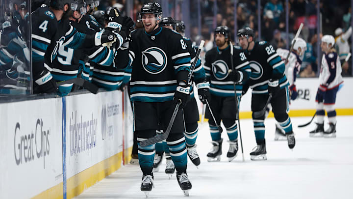 The San Jose Sharks celebrate a goal as the Blue Jackets look on.