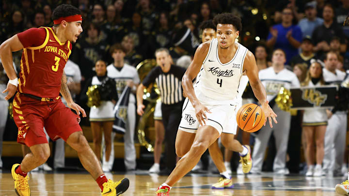 Feb 11, 2025; Orlando, Florida, USA;  Central Florida Knights center Keyshawn Hall (4) dribbles the ball up the court while Iowa State Cyclones guard Tamin Lipsey (3) attempts to defend at Addition Financial Arena. Mandatory Credit: Russell Lansford-Imagn Images