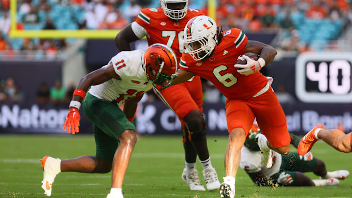 Sep 7, 2024; Miami Gardens, Florida, USA; Miami Hurricanes running back Damien Martinez (6) runs with the football against Florida A&M Rattlers defensive back Deco Wilson (11) at Hard Rock Stadium. Mandatory Credit: Sam Navarro-Imagn Images Sep 7, 2024; Miami Gardens, Florida, USA; Miami Hurricanes running back Damien Martinez (6) runs with the football against Florida A&M Rattlers defensive back Deco Wilson (11) at Hard Rock Stadium. Mandatory Credit: Sam Navarro-Imagn Images
