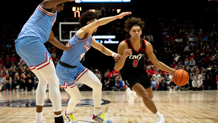 Cincinnati Bearcats guard Dan Skillings Jr. (0) drives on Dayton Flyers guard Koby Brea (4) in the first half of the NCAA men's basketball game between the Dayton Flyers and Cincinnati Bearcats at Heritage Bank Center in Cincinnati on Saturday, Dec. 16, 2023. Cincinnati Bearcats guard Dan Skillings Jr. (0) drives on Dayton Flyers guard Koby Brea (4) in the first half of the NCAA men's basketball game between the Dayton Flyers and Cincinnati Bearcats at Heritage Bank Center in Cincinnati on Saturday, Dec. 16, 2023.
