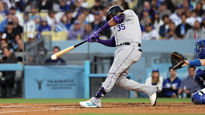 Jun 1, 2024; Los Angeles, California, USA;  Colorado Rockies catcher Elias Diaz (35) hits a single during the third inning against the Los Angeles Dodgers at Dodger Stadium. Mandatory Credit: Kiyoshi Mio-USA TODAY Sports