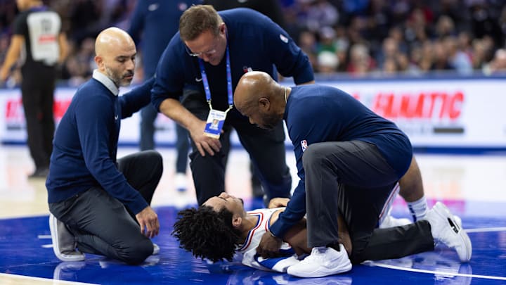 Oct 16, 2024; Philadelphia, Pennsylvania, USA; Philadelphia 76ers guard Jared McCain (20) is helped by training staff while on the floor after being injured on a play against the Brooklyn Nets during the fourth quarter at Wells Fargo Center. Mandatory Credit: Bill Streicher-Imagn Images