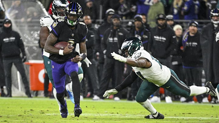 Dec 1, 2024; Baltimore, Maryland, USA; Baltimore Ravens quarterback Lamar Jackson (8) rushes p[assed Philadelphia Eagles linebacker Nakobe Dean (17) during the first half  at M&T Bank Stadium.  