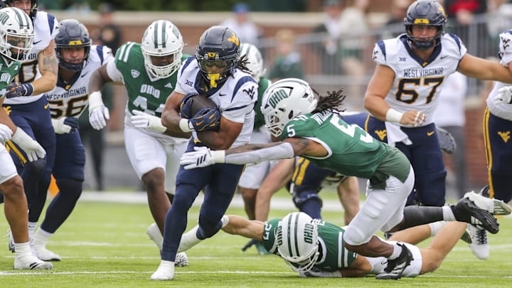 Sep 6, 2025; Athens, Ohio, USA; West Virginia Mountaineers running back Jahiem White (1) runs the ball and is tackled by Ohio Bobcats safety Adonis Williams Jr. (5) during the first quarter at Peden Stadium. Mandatory Credit: Ben Queen-Imagn Images