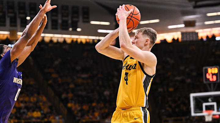 Feb 22, 2025; Iowa City, Iowa, USA; Iowa Hawkeyes guard Josh Dix (4) shoots the ball over Washington Huskies guard Mekhi Mason (0) during the second half at Carver-Hawkeye Arena. Mandatory Credit: Jeffrey Becker-Imagn Images