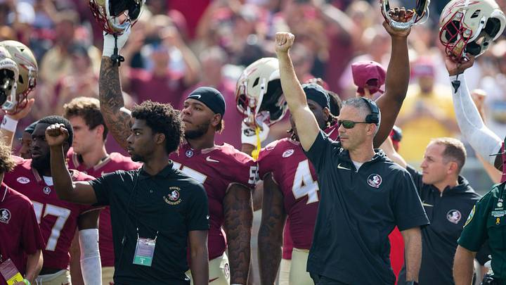 Florida State Seminoles head coach Mike Norvell stands with players as the spear is planted on the 50-yard line. The Florida State Seminoles lead the Virginia Tech Hokies 22-10 at the half on Saturday, Oct. 7, 2023.