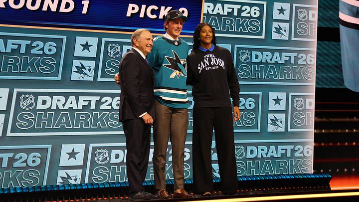 Jun 26, 2026; Buffalo, New York, USA; Keaton Verhoeff reacts beside NHL commissioner Gary Bettman and PWHL San Jose player Laila Edwards after being selected with the ninth pick in the first round of the 2026 NHL Draft by the San Jose Sharks at KeyBank Center. Mandatory Credit: Timothy T. Ludwig-Imagn Images